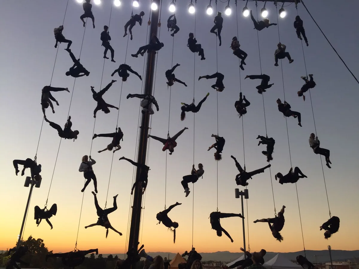 Acrobazia aerea: decine di performer sospesi al tramonto